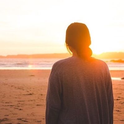 Eine junge Frau im Abendlicht am Strand