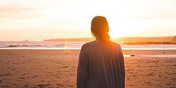 Eine junge Frau im Abendlicht am Strand