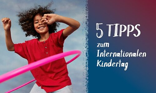 Eine Junge in rotem T-Shirt lässt einen Hula Hoop Ring kreisen.