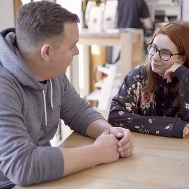 Zwei Personen sitzen an einem Tisch in einem Café.