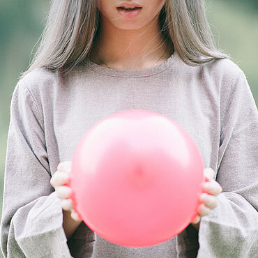 Junge Frau mit einem pinken Luftballon