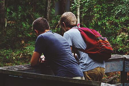 Zwei Jungen stehen in einem Wald.
