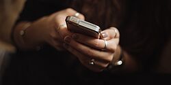 Priscilla du Preez, Unsplash Eine Person hält ein Smartphone in der Hand und tippt.