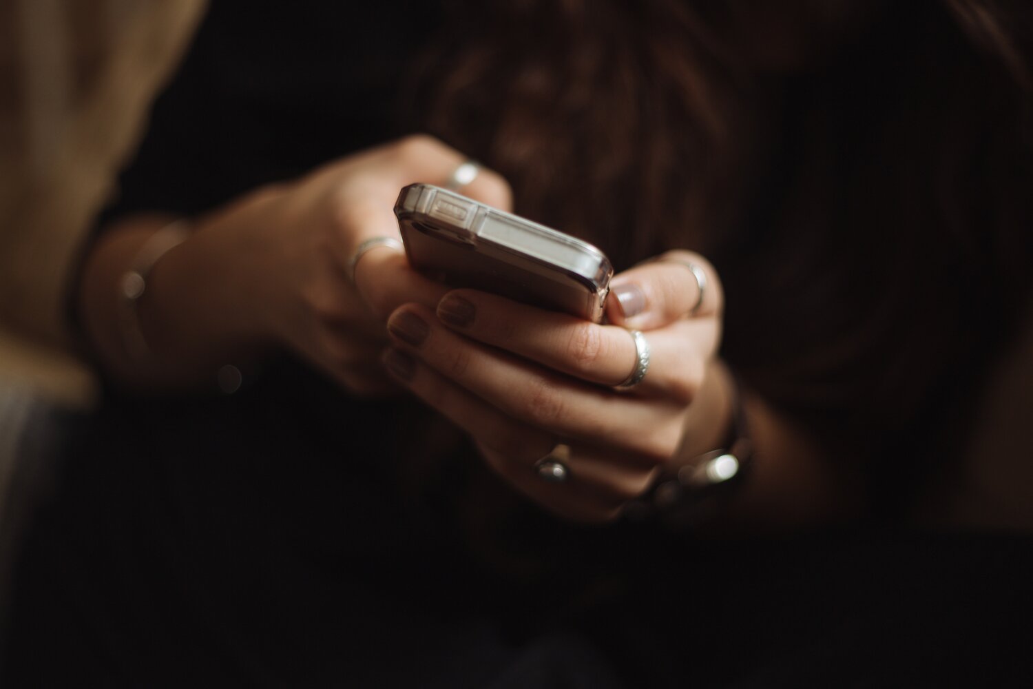 Eine Person hält ein Smartphone in der Hand und tippt.