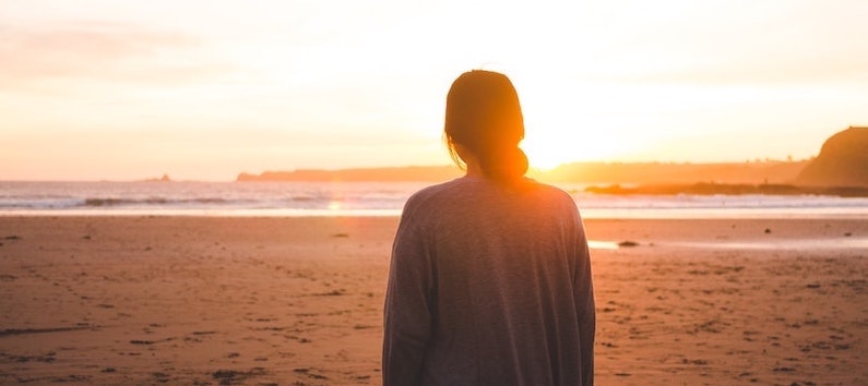 Eine junge Frau im Abendlicht am Strand